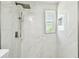 Shower features white marble-style tiles and a window at 16138 Manorwood Cir, Tampa, FL 33624