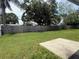 Spacious backyard with lush green grass, a concrete patio, and mature trees, providing ample space for outdoor activities at 1814 Driftwood S Cir, Oldsmar, FL 34677