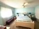 Bright bedroom features a ceiling fan, coastal decor, and plenty of natural light from the large window at 1814 Driftwood S Cir, Oldsmar, FL 34677