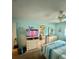 Cozy bedroom with a ceiling fan, comfortable bed, dresser, and a view into the en-suite bathroom at 1814 Driftwood S Cir, Oldsmar, FL 34677