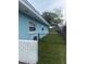 Side yard view with a well-maintained lawn, fence, and hose, ideal for outdoor activities at 1814 Driftwood S Cir, Oldsmar, FL 34677