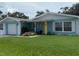 Charming, single-story home with a yellow door and well-manicured front lawn and garden at 1814 Driftwood S Cir, Oldsmar, FL 34677