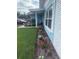 Charming home featuring a well-manicured lawn, beautiful flowers, and a quaint covered porch with seating at 1814 Driftwood S Cir, Oldsmar, FL 34677