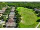 Aerial view of a home near a lush golf course with mature trees and other homes in the community at 19309 Seacove Dr, Lutz, FL 33558