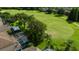 Aerial backyard view featuring a screened-in pool, lush landscaping, and golf course views at 19309 Seacove Dr, Lutz, FL 33558
