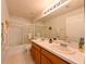 Bathroom featuring double sinks, a large mirror, and a bathtub/shower with glass doors at 19309 Seacove Dr, Lutz, FL 33558