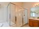 Bathroom featuring walk-in shower with glass door, tile walls, and vanity with single sink and wood cabinets at 19309 Seacove Dr, Lutz, FL 33558