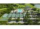 Aerial view of community amenities, highlighting tennis courts, playground, clubhouse, pool, and parking at 19309 Seacove Dr, Lutz, FL 33558
