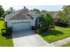 Well-maintained home exterior featuring a two-car garage, arched entryway, and manicured landscaping at 19309 Seacove Dr, Lutz, FL 33558