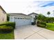 Attractive home showcasing a two-car garage, manicured hedges, and vibrant landscaping at 19309 Seacove Dr, Lutz, FL 33558
