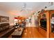 Open-concept living room with hardwood floors, adjacent kitchen, decor shelves and comfortable leather seating at 19309 Seacove Dr, Lutz, FL 33558