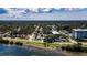 Breathtaking aerial view of a waterfront community with lush green trees and residences under a partly cloudy sky at 1951 Edgewater Dr, Clearwater, FL 33755