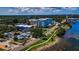 Expansive aerial view showcasing waterfront properties with pools, lush landscaping, and nearby commercial buildings at 1951 Edgewater Dr, Clearwater, FL 33755