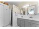 Bathroom featuring a shower and double sink vanity with gray cabinetry and white countertop at 1951 Edgewater Dr, Clearwater, FL 33755