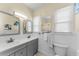 Bathroom with double sink vanity, gray cabinets, tile floor, and a toilet at 1951 Edgewater Dr, Clearwater, FL 33755