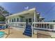 Charming white home with a blue deck, offering an inviting outdoor living space with scenic views at 1951 Edgewater Dr, Clearwater, FL 33755