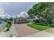 Exterior view of charming home featuring an inviting front yard, brick driveway, and beautiful curb appeal at 1951 Edgewater Dr, Clearwater, FL 33755