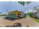 Home's architectural design features arched windows, complemented by a brick driveway and lush landscaping at 1951 Edgewater Dr, Clearwater, FL 33755