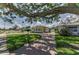 Charming yellow home with arched windows, a brick driveway, and luscious green lawn at 1951 Edgewater Dr, Clearwater, FL 33755
