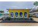 Charming yellow home featuring unique arched windows and well-manicured landscaping for curb appeal at 1951 Edgewater Dr, Clearwater, FL 33755