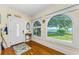 Warm foyer featuring hardwood floors, arched windows with water views, and decorative accents at 1951 Edgewater Dr, Clearwater, FL 33755