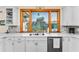 Kitchen sink features a large window, white counter tops and stone backsplash at 1951 Edgewater Dr, Clearwater, FL 33755