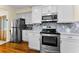 Stainless steel appliances accent this kitchen with stone backsplash at 1951 Edgewater Dr, Clearwater, FL 33755