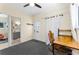 Office area with neutral walls, carpeted floor, ceiling fan, exterior door, and interior bathroom entrance at 1951 Edgewater Dr, Clearwater, FL 33755