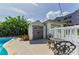 A charming storage shed and seating area overlook the luxurious pool at 1951 Edgewater Dr, Clearwater, FL 33755