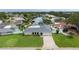 Beautiful aerial view of a home with lush landscaping, a well-manicured lawn, and a brick driveway at 1964 Tanglewood Ne Dr, St Petersburg, FL 33702