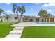 Lush backyard featuring a pool, covered patio, and manicured lawn, blending luxury with outdoor living at 1964 Tanglewood Ne Dr, St Petersburg, FL 33702