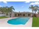 Beautiful backyard with a pristine pool, covered patio, lush greenery, and palm trees for a tropical oasis at 1964 Tanglewood Ne Dr, St Petersburg, FL 33702
