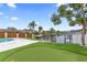 Serene backyard with a lush lawn, putting green, and waterfront views, offering a perfect outdoor retreat at 1964 Tanglewood Ne Dr, St Petersburg, FL 33702