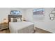 Cozy bedroom featuring a tufted headboard, stylish lamps, and bright natural light from large windows at 1964 Tanglewood Ne Dr, St Petersburg, FL 33702