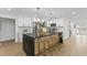 Modern kitchen with a black island, marble backsplash, stainless steel appliances, and white cabinets at 1964 Tanglewood Ne Dr, St Petersburg, FL 33702