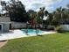 A lush backyard featuring a pool with lounge chairs, large trees, green grass, and plenty of space at 2005 Capri Rd, Valrico, FL 33594