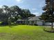Spacious property featuring a well-kept lawn, mature trees, and a charming home, blending comfort and nature at 2005 Capri Rd, Valrico, FL 33594