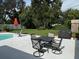 Backyard patio with outdoor dining table, lounge chairs, and pool partially visible at 2005 Capri Rd, Valrico, FL 33594