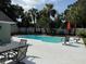 Backyard with a large pool, patio seating, lounge chairs, palm trees, and white fence at 2005 Capri Rd, Valrico, FL 33594