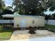 Backyard shed with covered patio, flower garden, and stone paver flooring at 2005 Capri Rd, Valrico, FL 33594