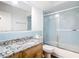 Bathroom featuring a vanity with a granite countertop and a tiled shower with glass doors at 20352 Astoria Ave, Port Charlotte, FL 33952