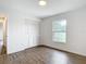 Clean bedroom with modern flooring, a window with natural light, and a closet with bifold doors at 20352 Astoria Ave, Port Charlotte, FL 33952