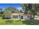 Charming home featuring stone accents, a well-maintained lawn, and an inviting arched front entrance at 20352 Astoria Ave, Port Charlotte, FL 33952