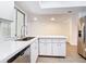Modern kitchen featuring white cabinets, stainless steel appliances, and ample counter space with open floor plan at 20352 Astoria Ave, Port Charlotte, FL 33952