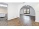 Open living space showcasing wood-look floors, arched doorway, and access to the kitchen at 20352 Astoria Ave, Port Charlotte, FL 33952