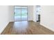 Open living space with wood-look floors, access to a pool and kitchen, and neutral white walls at 20352 Astoria Ave, Port Charlotte, FL 33952