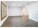Living room featuring wood-look floors, large window, and white walls with modern baseboards at 20352 Astoria Ave, Port Charlotte, FL 33952