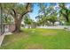 Spacious backyard with a detached garage and a large shade tree at 205 W Wheeler Rd, Seffner, FL 33584
