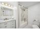 Bright bathroom featuring a marble countertop, stylish gold fixtures, and shower with matching marble tiling at 205 W Wheeler Rd, Seffner, FL 33584