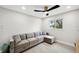Bright bedroom with a comfortable couch, stylish floors, modern ceiling fan and lights, and natural light from the window at 205 W Wheeler Rd, Seffner, FL 33584